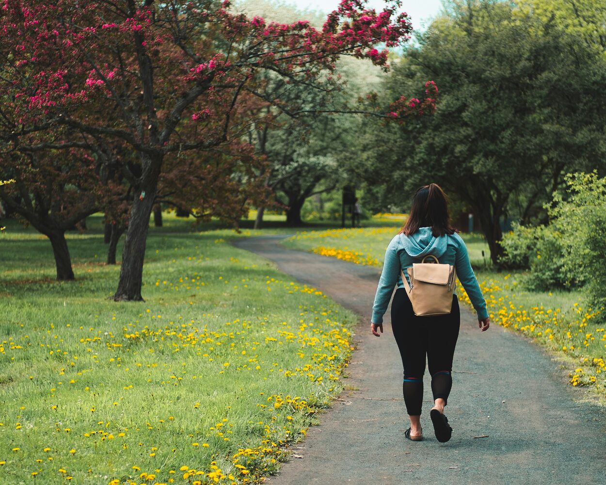 une femme qui marche dans un parc vert activité physique au quotidien